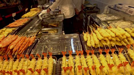 vendedor cocinando espigas de tempura en el puesto de la calle kyoto