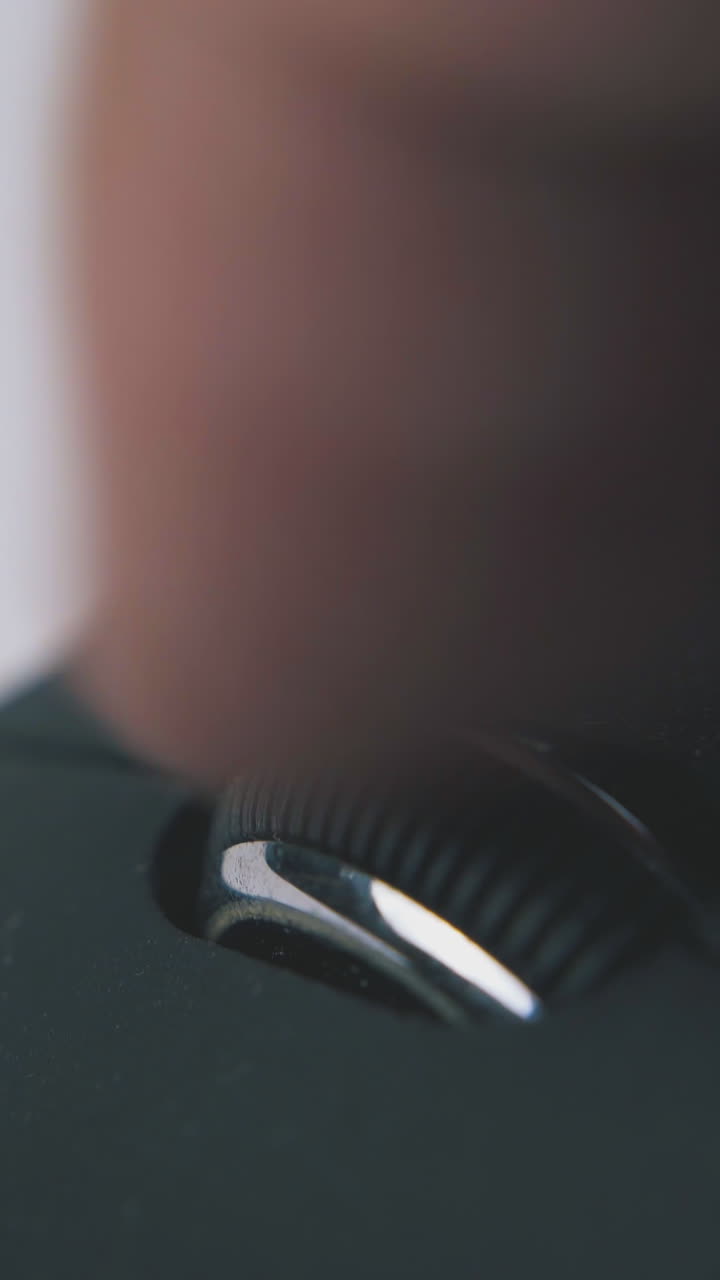 young man scrolls wheel and presses buttons of modern computer mouse on white surface extreme close view
