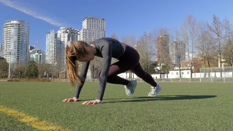 Young-athletic-woman-doing-plank-knee-raises-exercise
