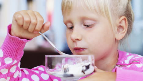 A-cheerful-child-eats-ice-cream-in-a-cafe