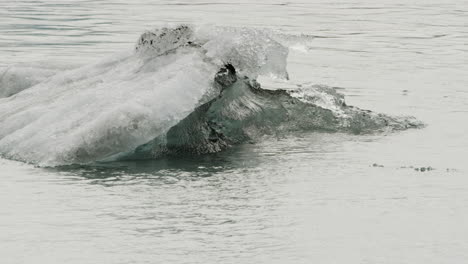 Locked-off-close-up-shot-of-a-small-Iceberg-floating-past-in-Iceland