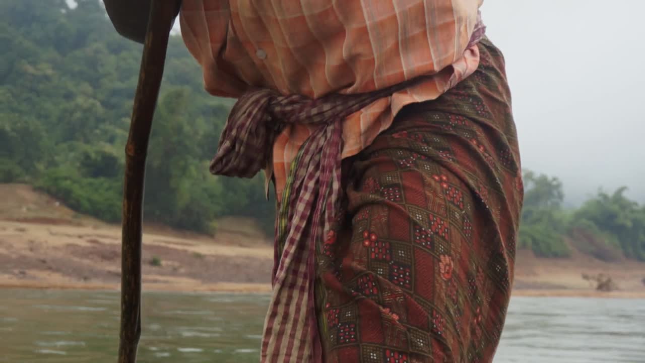 hombre empujando un bote río arriba en india