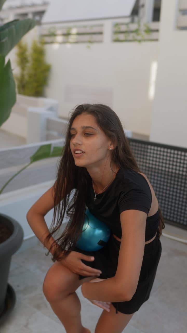 una adolescente practicando ejercicio con la pelota al aire libre