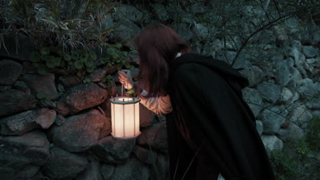 una mujer misteriosa busca mensajes ocultos entre las paredes de piedra religiosas de la noche.