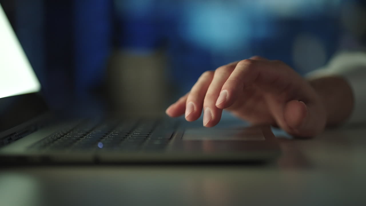 Close-Up male Fingers On Laptop Touchpad. man Surfing The Web In The Dark. Shopping Online. man working with notebook laptop using finger with keyboard and touchpad or trackpad for slide and zoom in.