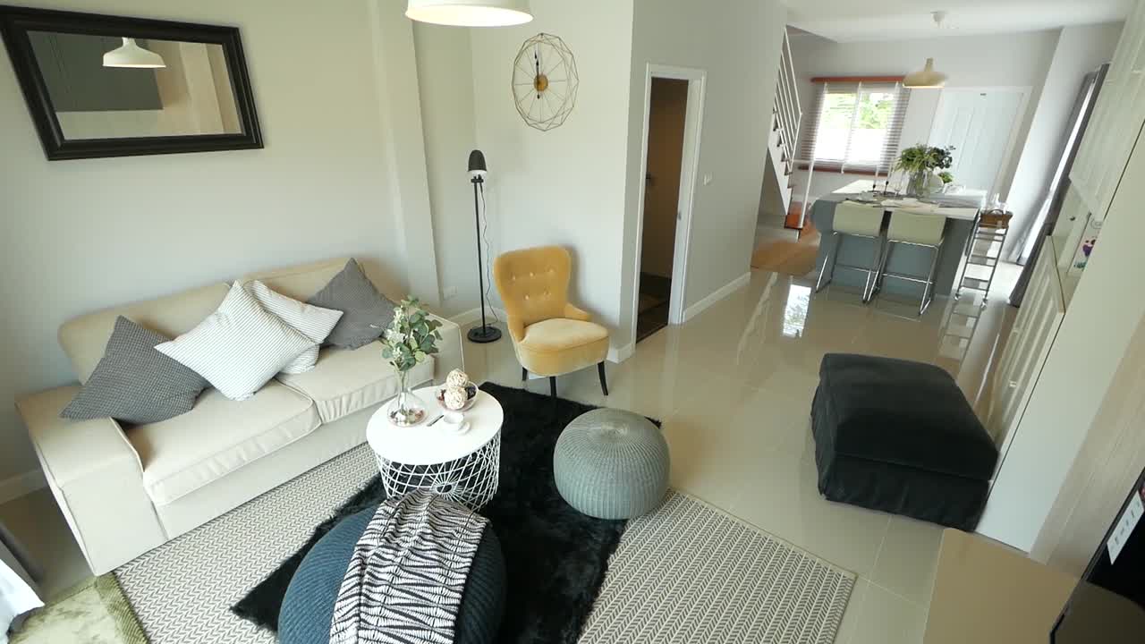 sala de estar estilosa e aconchegante, mobiliada com poltrona, sofá, almofadas