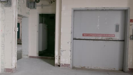 A-pan-shot-of-a-closed-freight-elevator-in-an-abandoned-factory