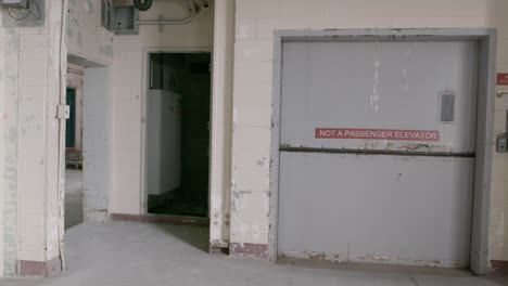 una foto de un ascensor de carga cerrado en una fábrica abandonada