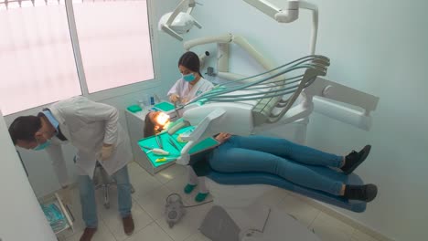 High-angle-shot-of-woman-removing-tooth-at-the-dentist