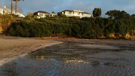 Niedrig-Fliegende-Drohnenaufnahmen-Vom-Strand-Bei-Ebbe-Mit-Reflexionen-Im-Stillen-Wasser