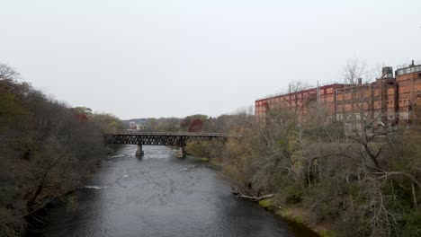 puente de madera que cruza un río oscuro y rápido