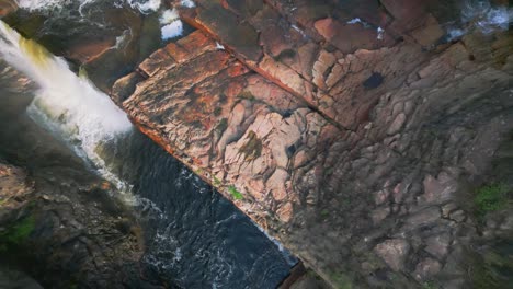 water flows down a waterfall in chapada dos veadeiros national park, goiás, brazil, creating a stunning natural spectacle viewed from above, showcasing the power of nature, drone overhead descending