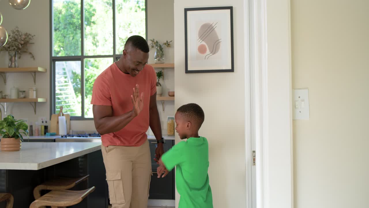 African American father and son placing mark atop son's head marking hall height highfiving hugging