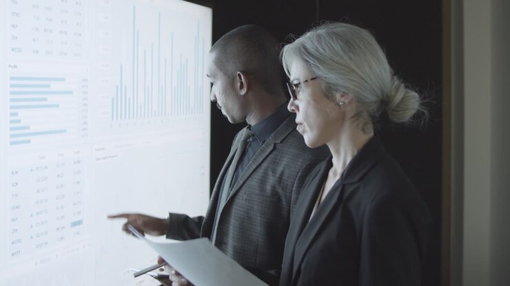 Finance broker explaining stock market statistics to investor