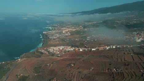 slow aerial pan across coastal farming village in spain, clouds in sky