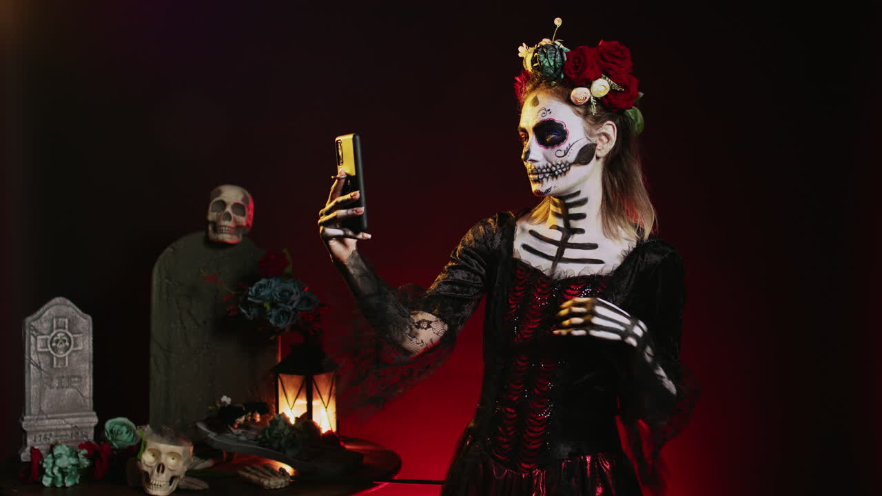 A woman in day of the dead make up takes a selfie