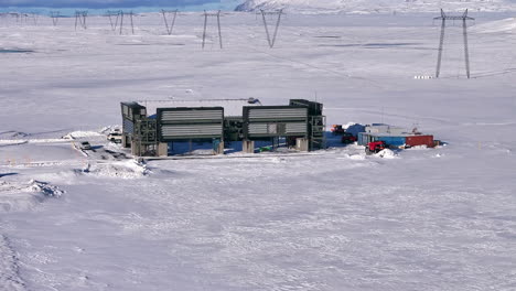 Snow-covered-direct-air-capture-facility-in-Iceland-with-truck-in-front,-wide-shot