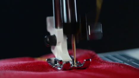 sewing machine stitching seam on fabric. yellow thread pattern on red fabric