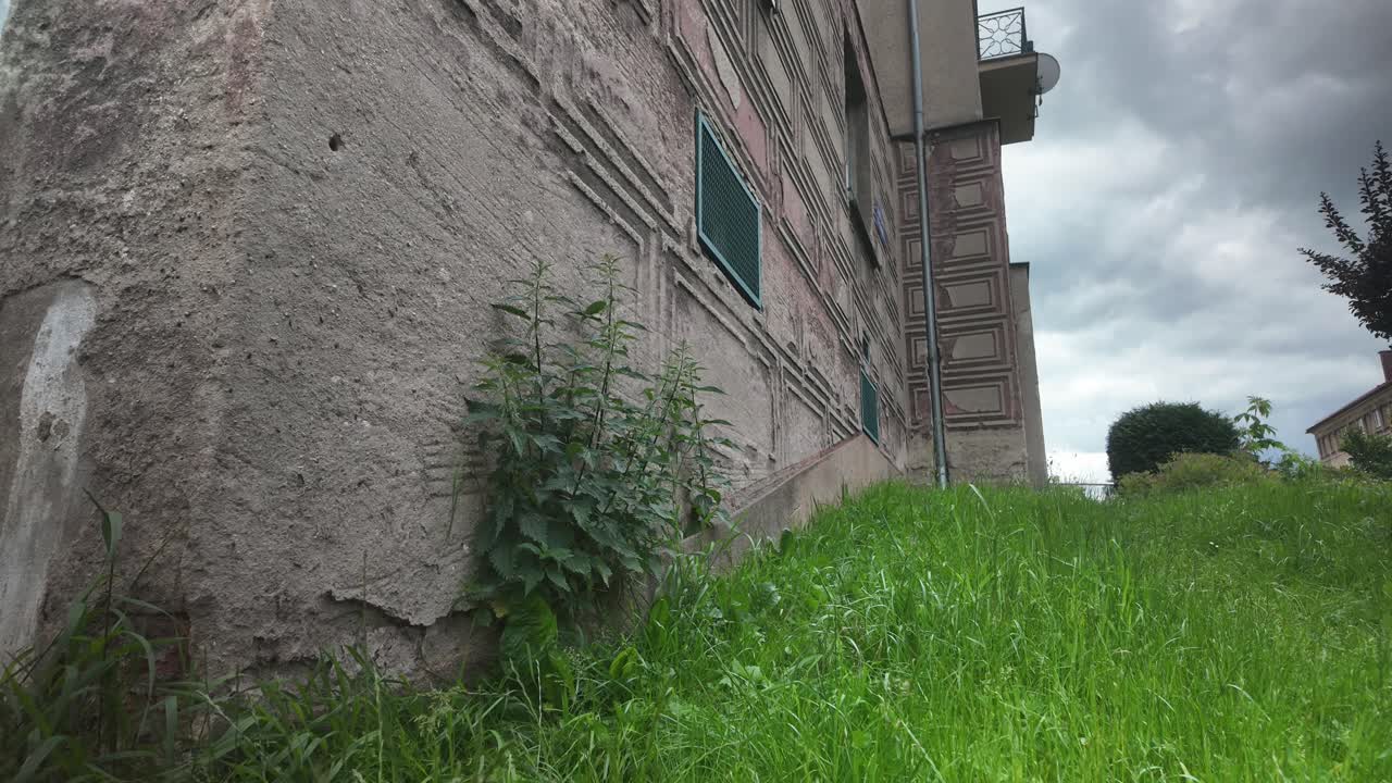 Concrete eroding on bleak Soviet era apartment block, cloud time lapse