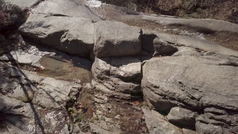 drone flying over stream and cliff to reveal big waterfall in vermont