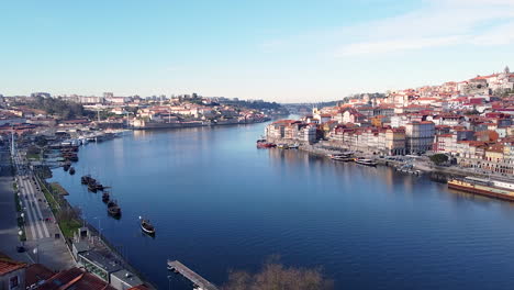 Vista-Aérea-De-Las-Orillas-Del-Río-Douro,-Gaia-Y-Oporto-En-Un-Día-Soleado,-Drone-En-El-Futuro