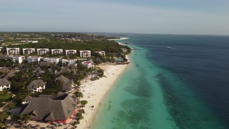 vista aérea de drones de una playa paradisíaca con agua turquesa limpia en un lugar turístico con resorts y hoteles en nungwi, zanzíbar, áfrica 4k