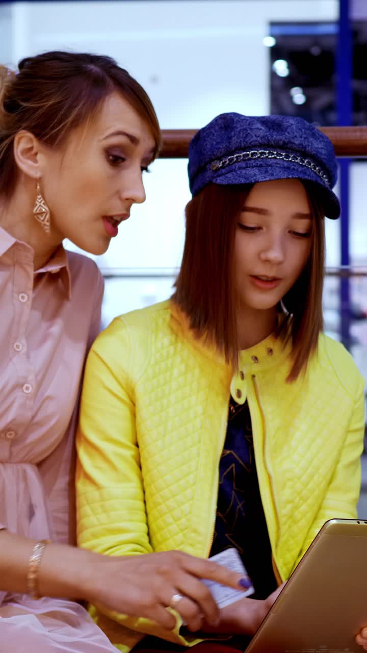 Woman helping a girl shop online