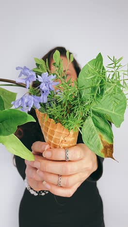 woman holding a floral arrangement in an ice cream cone