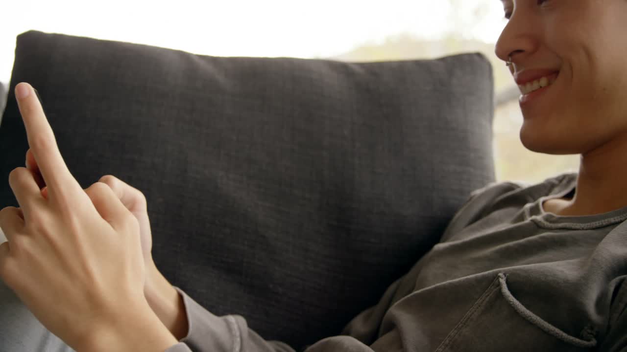 joven usando el móvil en casa 4k