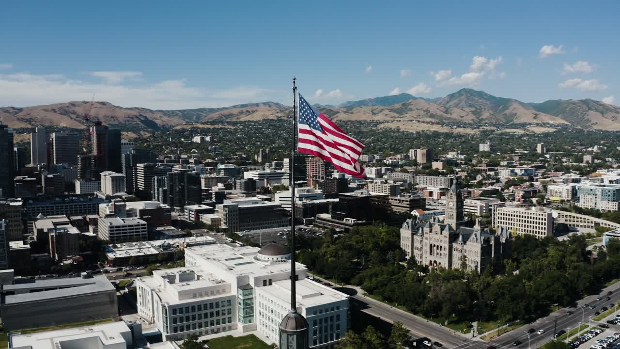Aerial view of a flag overlooking Salt Lake City's downtown sector on a sunny day