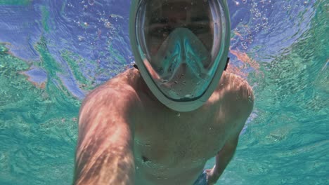 pov of man diving down and snorkeling in clear water