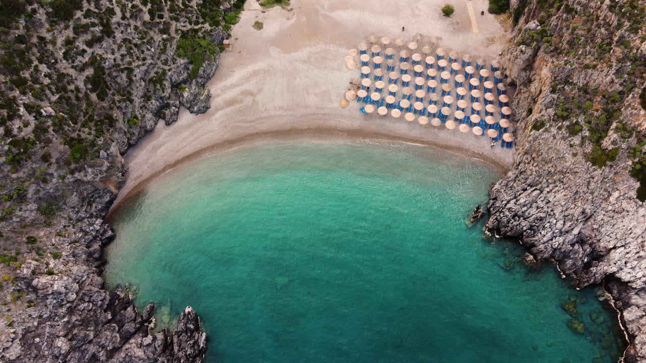 Aerial Drone shot of Chalkos Beach, Kythira, Greece. Drone rises up revealing more of the crystal clear waters and pebbled beach.