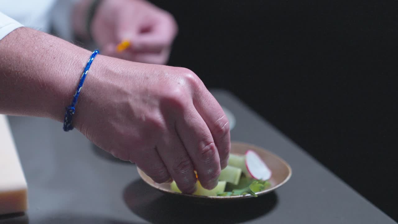 A sliding shot of a chef placing decorative touches on sushi rolls, showcasing sushi preparation and presentation. Perfect for highlighting Japanese cuisine and food styling in culinary settings.
