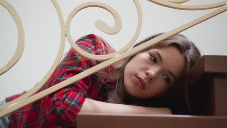 a young woman sits on the stairs looking sad and unhappy.