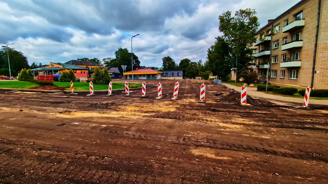 Ulica w mieście zablokowana z powodu przebudowy, ze znakami ostrzegawczymi i wykopami.