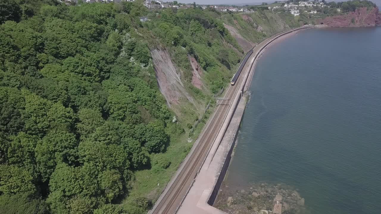 카메라를 떠나는 열차와 함께 해안가를 따라 teignmouth 철도 노선