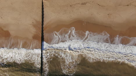 aerial looking down to the right motion peaceful golden colored beach from with waves crashing bournemouth uk english channel surf pacific ocean