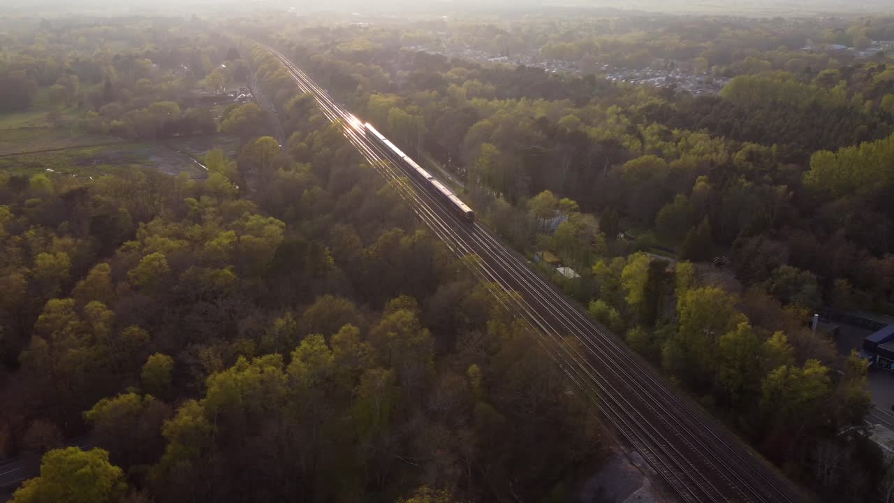 Beautiful aerial shot following a train travelling at sunset in nature