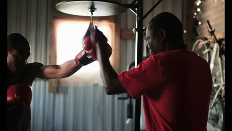 Afroamerikanischer-Boxer-übt-Boxen-Mit-Trainer-Im-Fitnessstudio-4k