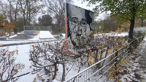 Pan-up-handheld-cameraon-a-part-of-the-Berlin-wall-in-wintertime-in-the-Hasenheide-park-covered-with-snow-HD-30-FPS-6-secs