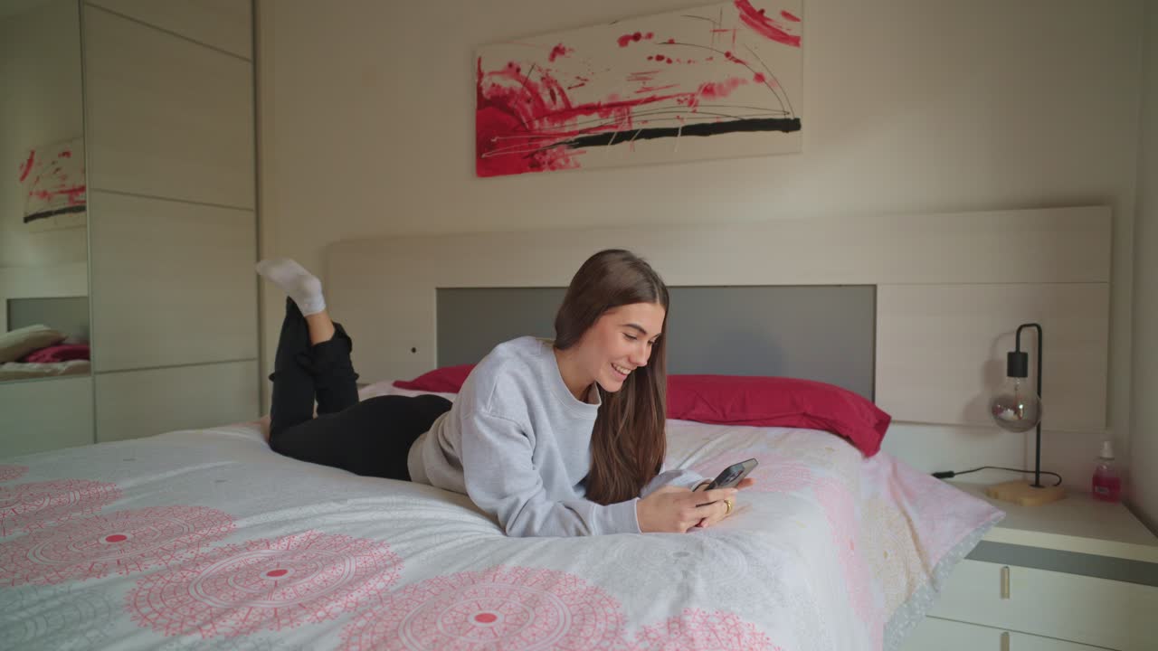 Woman using smartphone lying on bed