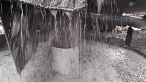 a close up shot of water is coming out of the casing pipe during the digging of the borewell by borewell machine.