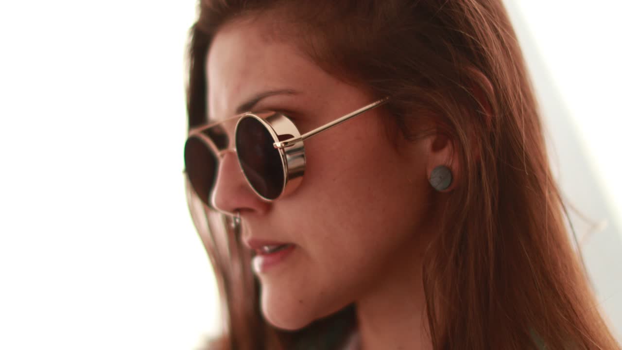 una chica millennial con gafas de sol redondas y frescas.