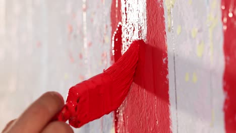 Un-Hombre-Está-Pintando-Una-Pared-De-Color-Rojo-Con-Pincel,-Primer-Plano,-Insertar-Foto