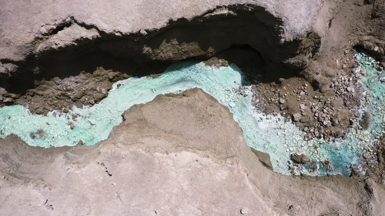 manantiales termales del mar muerto dramático tiro aéreo de arriba hacia abajo siguiendo el paisaje del cañón del desierto con aguas cristalinas y cálidas piscinas de roca