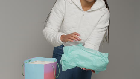 close up of female social media influencer producing user generated content taking beautiful green shoes out of shopping bag 3