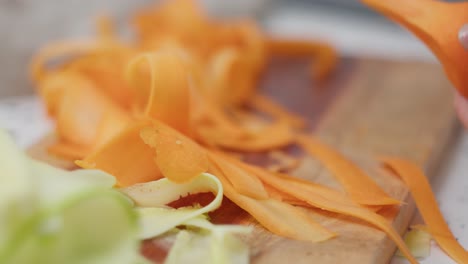 woman hand peeling carrot, close up view