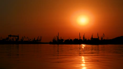 beautiful orange sky wiht big sun at sunset with a view of the harbour