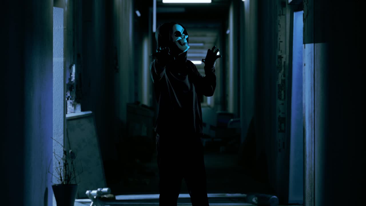 버려진 호텔에 서 있는 유령 마스크를 입은 허드 인 무서운 남자, 공포 장면