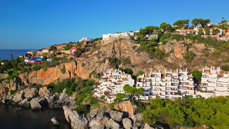 Aerial-drone-forward-moving-shot-flying-over-a-beautiful-resort-along-rocky-beach-in-Playa-Marina-del-Este,-Almunecar,-Granada,-Spain